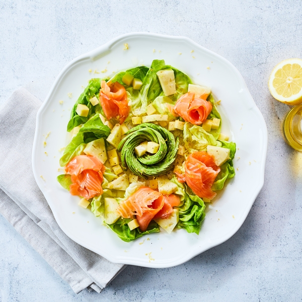 Tropische salade van kropsla met avocado, gerookte zalm, ananas en mango