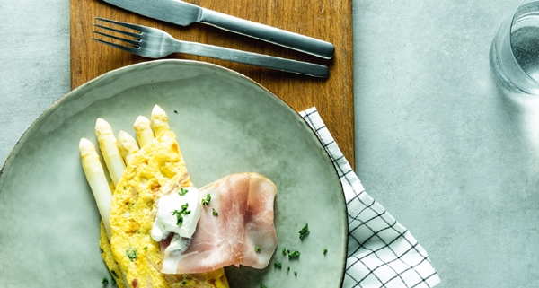 gekookte witte asperges, geserveerd in omelet met ham